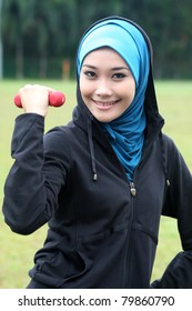 A Muslim Woman Exercising With Dumbell Weights