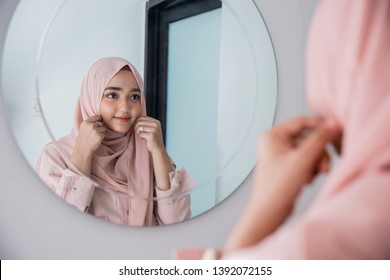 muslim woman fix and make up her self looking at the mirror