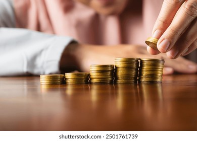 muslim woman hand stacking coins money symbol for financial banking investment dividend from business growth concept - Powered by Shutterstock