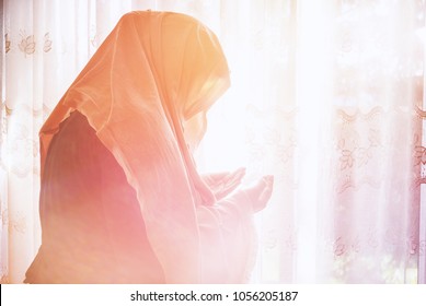 Muslim Woman Have A Pray Time With Hands Up In The Air Dua Pose. Light Beams Comming From Heaven Bright Window.