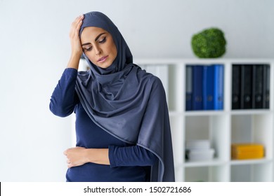 Muslim Woman Having A Severe Headache. Female Office Worker Tired And Feel Bad. Stress And Health.