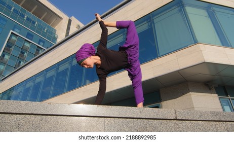 Muslim Woman In Hijab In City Doing Workout Training Strength Stretch Practicing Effort Stretching Pose Female Aerobics Sport On Street Motion Three Legged Downward Facing Dog Asana Bottom View