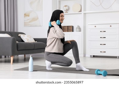 Muslim woman in hijab doing exercise on fitness mat at home - Powered by Shutterstock