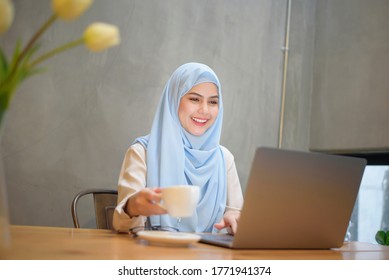 Muslim Woman With Hijab Is Working With Laptop Computer In Coffee Shop