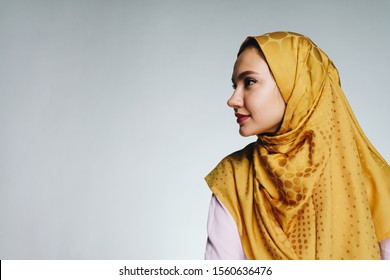 muslim woman with makeup in profile on gray background