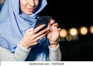 Muslim Woman Messaging On A Mobile Phone In Cafe