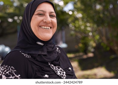 Muslim woman, portrait and happy in nature in hijab, relax and mature person on vacation in outdoor. Islamic female, smile face and religion in scarf in garden and sunshine in morning on retirement - Powered by Shutterstock