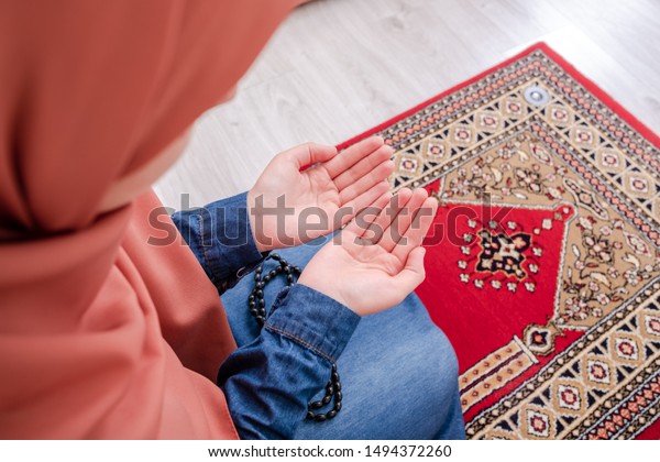 Muslim woman prayer, muslim girl open hands praying\
with rug