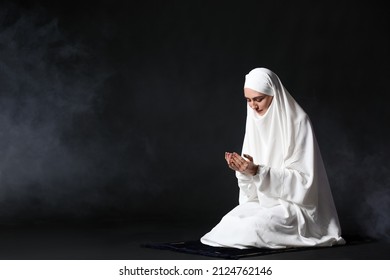 Muslim Woman Praying On Dark Background