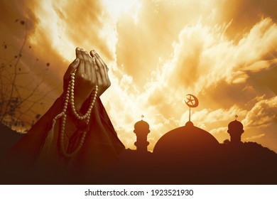 Muslim Woman Praying With Prayer Beads On His Hands With A Dramatic Sky Background