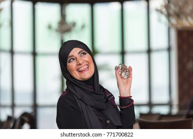 Muslim woman putting on perfume - Powered by Shutterstock