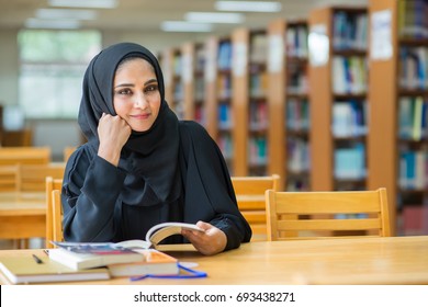 Muslim Woman Reading Book At The Library.