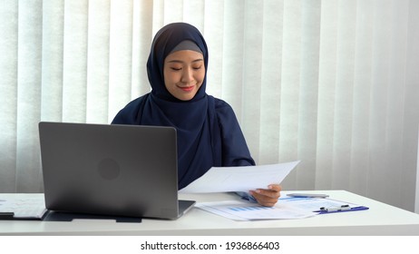 Muslim Woman Sitting Happily At The Office.