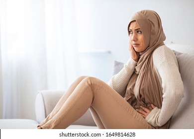 Muslim woman suffering abdominal pain, period cramp, needs medical aid. Diarrhea Concept. Muslim Woman In Headscarf Touching Her Belly, Suffering From Strong Abdominal Pain, Having Menstrual Cramps