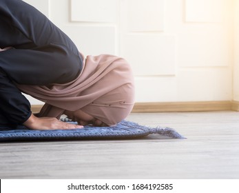 Muslim Woman In Traditional Clothing Bow Down With Faith And  Respect On The Carpet.