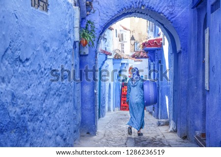 Muslim woman in a typical moroccan dress walking in a small street