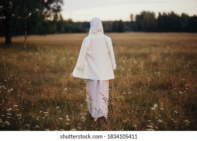 A Muslim Woman Walks In The Open Air. The View From The Back