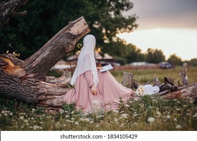 A Muslim Woman Walks In The Open Air. The View From The Back