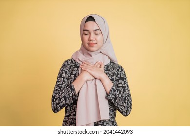 Muslim Woman Wearing Hijab Holding Chest And Eyes Closed With Patient Expression