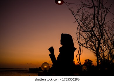 Muslim woman wearing a hijab in a silhouette photo against the sky, Tanjung Pinang, Riau Islands, Indonesia