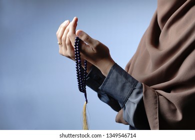                                A Muslim Woman Wearing Moslem Clothes With Hijab And Rosary, Praying In The Mosque, Muslim Woman Raising Hand Pray. -Image