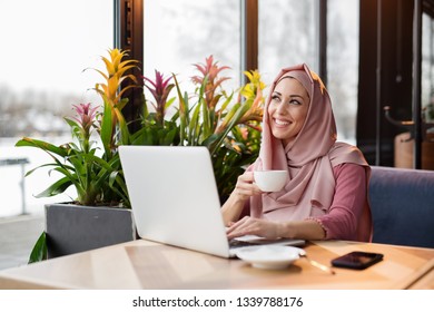 Muslim Woman Working At A Cafe And Using Computer And Drink Coffee