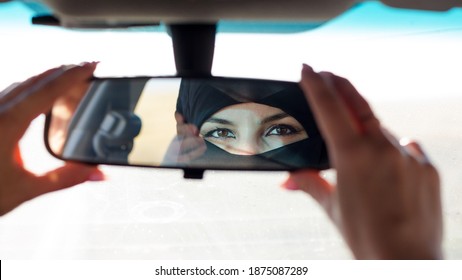 Muslim Woman's Eyes In The Rearview Mirror Of A Car.