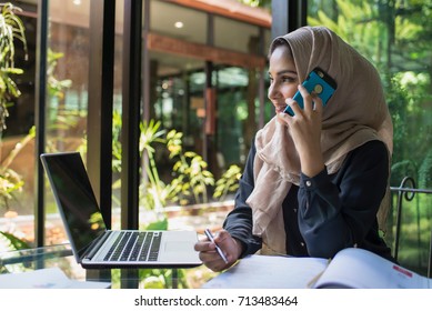 Muslim women working, she talking mobile phone.