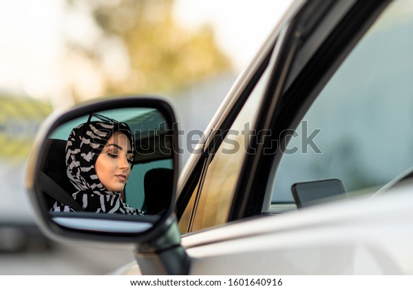 muslim young woman\
is driving car\
carelessly