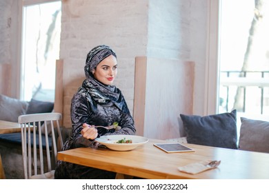 Muslim Young Woman Eating At Cafe With Food