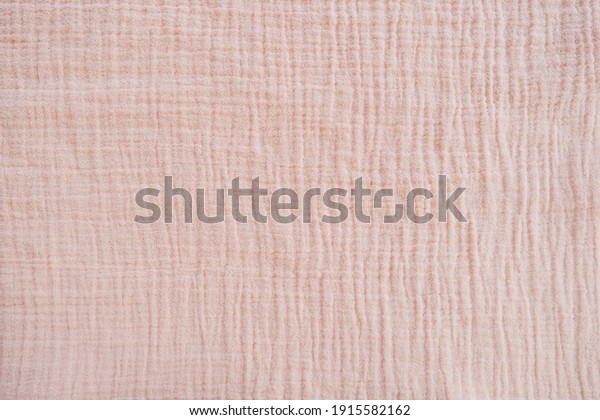 Muslin cloth texture background in neutral\
tones. Muslin cotton fabric of plain weave. Muslin is a soft,\
woven, 100-percent cotton multi-layer cloth popular for baby cloths\
and blankets.