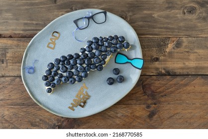 Mustache Shaped Cake With Blueberries And Decoration On Wooden Background. Copy Space. Father's Day. Masculine Concept.