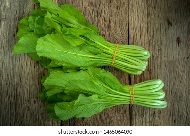 Mustard Greens On Wooden Table Isolated