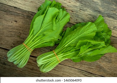 Mustard Greens On Wooden Table Isolated