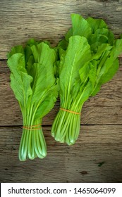 Mustard Greens On Wooden Table Isolated