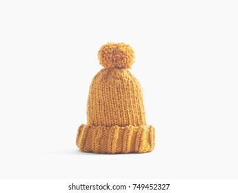 Mustard Knit Beanie Hat With Big Pom Pom Isolated On White Background. Copy Space. 