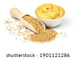 Mustard seeds in the wooden scoop and mustard sauce in the bowl isolated on white background.