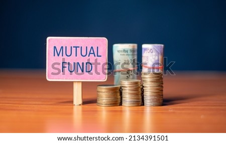 mutual fund sign board with growing coins and stack of money - concept of Investment, savings and wealth creation.