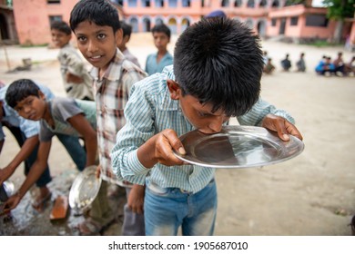 Muzaffarpur, Bihar, India,  25th July 2013: Student Washing  Their Food Plate Others Are Waiting In Queue During Mid Day Meal Lunch Break In Secondary School Of Rural India. 