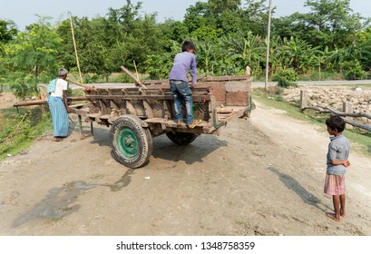Muzaffarpur, India -  March 15, 2019: A child is playing on a bullock cart while a man is pulling it.