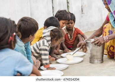 Muzaffarpur, India - May 10, 2017: A Lady Feeding Food To Poor Children In A Remote Village In India. India Ranked 97th Out Of 118 Countries On The IFPRI's Global Hunger Index (GHI) In 2016.