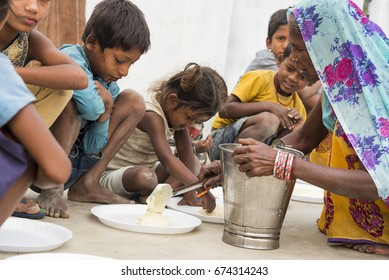 Muzaffarpur, India - May 10, 2017: A Lady Feeding Food To Poor Children In A Remote Village In India. India Ranked 97th Out Of 118 Countries On The IFPRI's Global Hunger Index (GHI) In 2016.