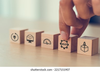 MVP, Minimum Viable Product Concept For Lean Startup. Life Cycle Of Product Development. Analysis And Market Validation. Hand Puts Wooden Cubes With Abbreviation MVP And Learn, Build, Measure Icons.