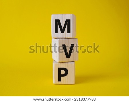 MVP - Most Valuable Player symbol. Wooden cubes with words MVP. Beautiful yellow background. Business and MVP concept. Copy space.