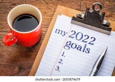 My 2022 Goals List On Clipboard And Coffee Against Grunge Wood Desk, Setting New Year Goals And Resolutions