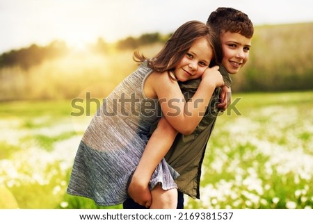 My big brother is my hero. Portrait of an adorable little boy giving his little sister a piggyback ride outside.