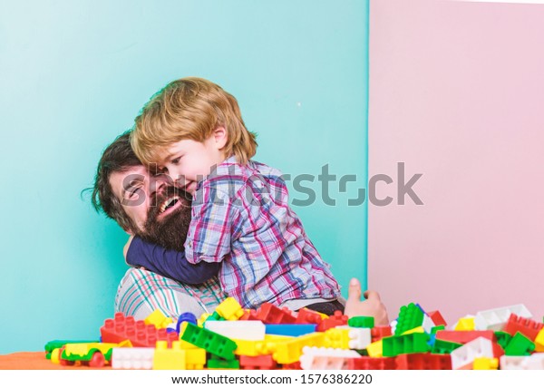 My family. father and son play game. small boy with\
dad playing together. happy family leisure. child development.\
building home with colorful constructor. I prepared surprise for\
you. i love you.