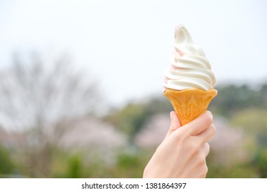 My favorite dessert during Japan trip - A little sour and sweet mix vanilla and strawberry soft serve ice cream waffle cone with pink cherry blossom background under clear blue sky - Powered by Shutterstock