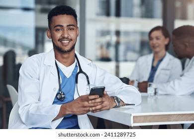 My favourite person just texted me. Shot of a young male doctor using his smartphone while taking a break. - Powered by Shutterstock