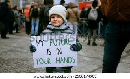 Image, Stock Photo Eco activist boy with banner “Wind Energy” on background of power stations for renewable electric energy production. Child and windmills. Wind turbines for generation electricity. Green energy